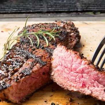 Perfectly cooked medium rare steak with fresh rosemary