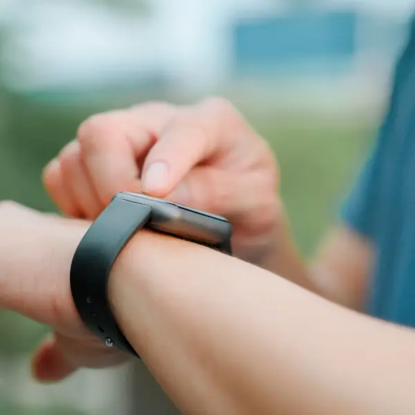 Person checking fitness watch representing protein timing and time based diets