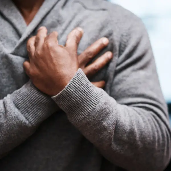Person holding chest representing heart health awareness