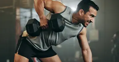 Man lifting dumbbells during intense gym workout